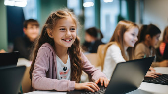 Photo élève fille en classe devant portable ordinateur sourire